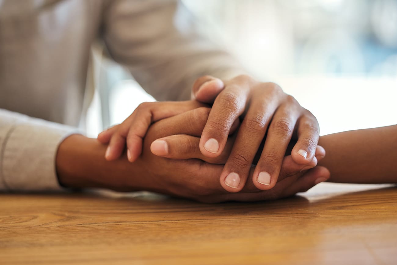 Close-up of a couple holding hands in a therapy session, symbolizing support and connection in couples counseling at Mount North.